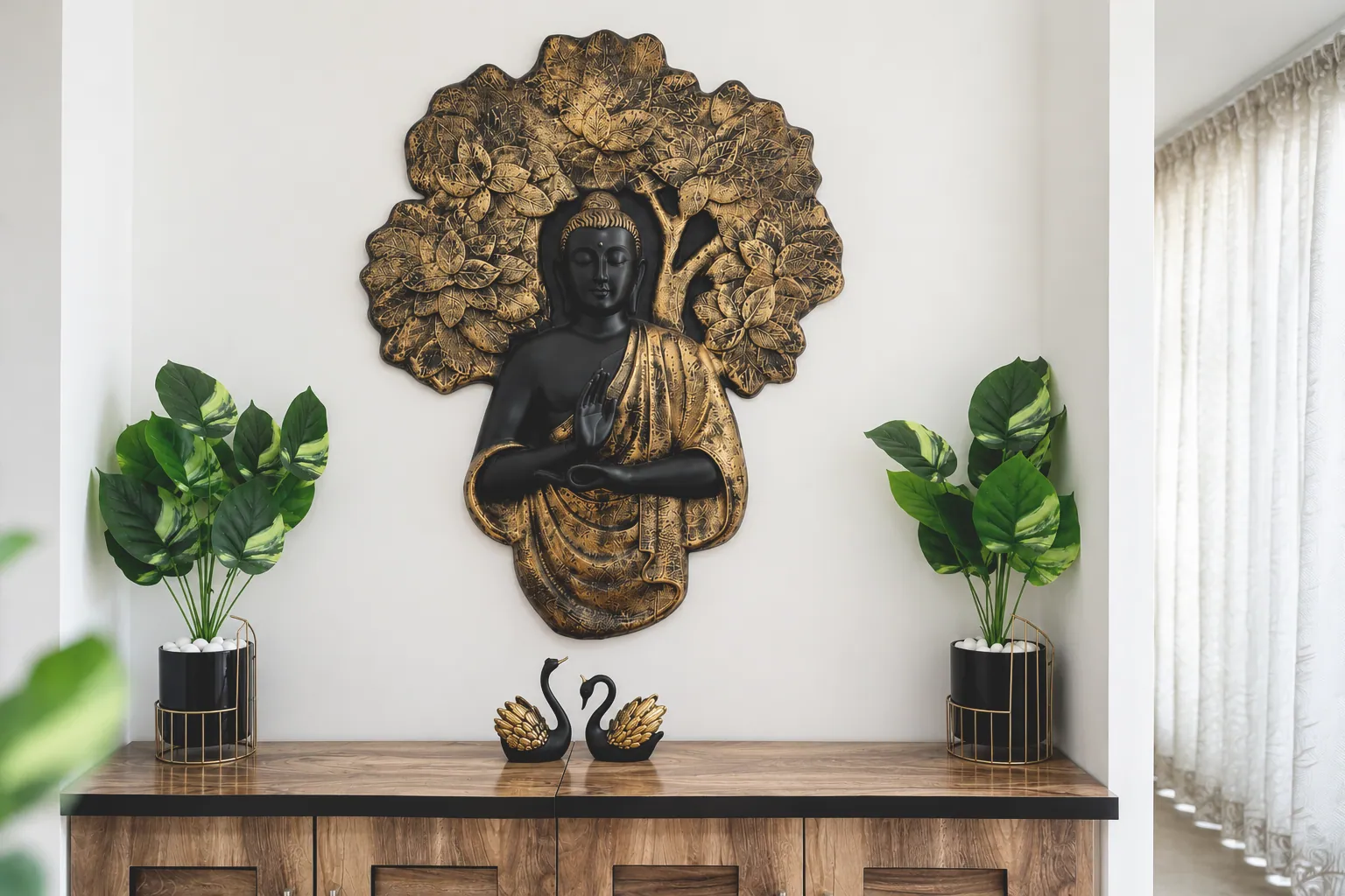 Black and gold Buddha wall artwork above a warm wooden console with leafy plants